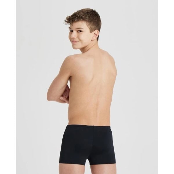 004777-550 i O Fato de Banho Menino Arena Team Swim Short Solid é um fato de banho desportivo para rapazes, inspirados nos equipamentos que criamos para federações de natação e atletas de elite. Medem 22 centímetros de lado e têm um formato quadrado moderno. Com um design simples em cor sólida e o nosso nome na cintura, estes calções de banho são feitos de um tecido produzido de forma responsável, oferecendo resistência superior ao cloro. Uma escolha inteligente para treinos competitivos.